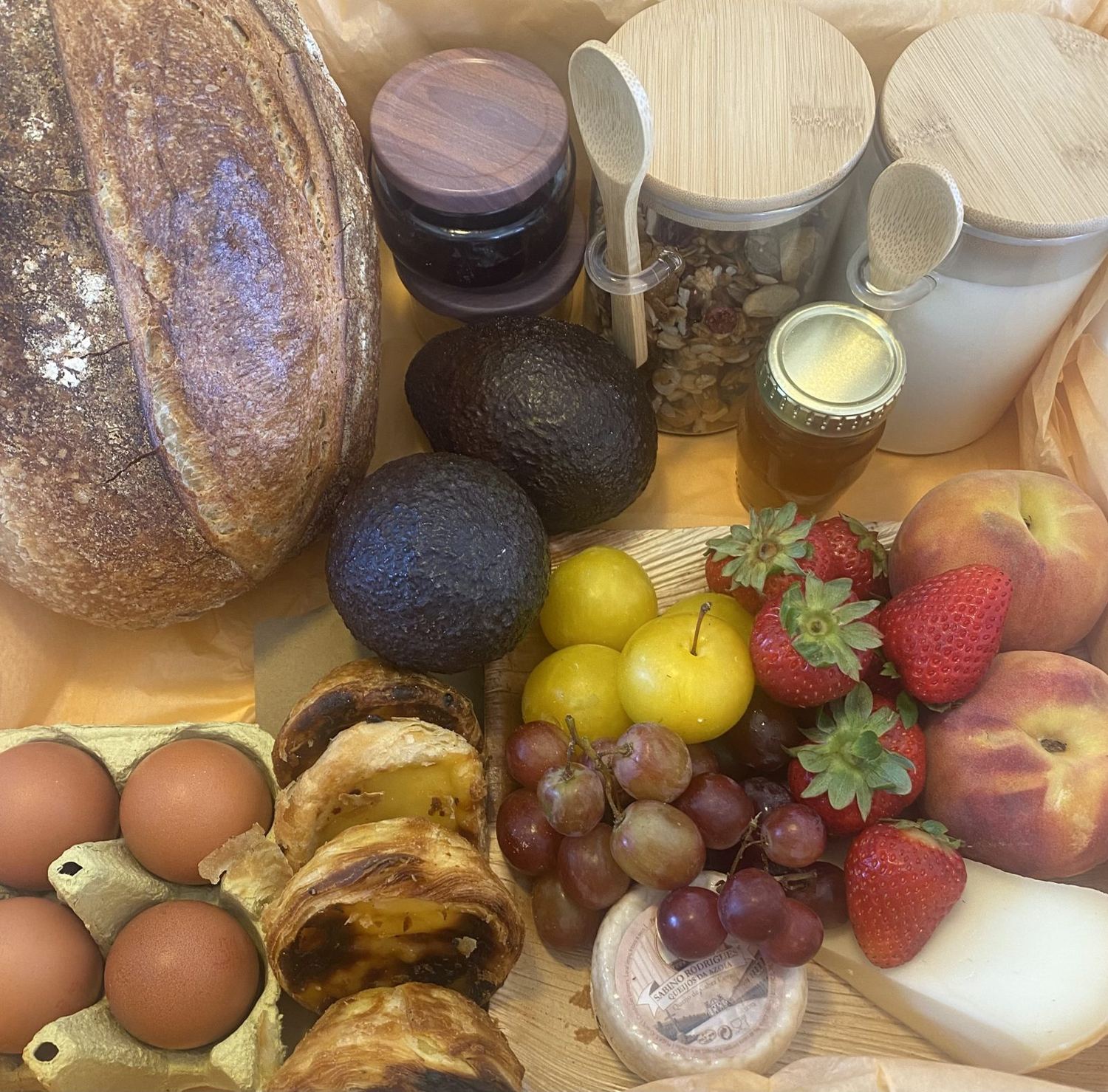 Breakfast box detail — summer fruit, homemade jam, granola and honey jars