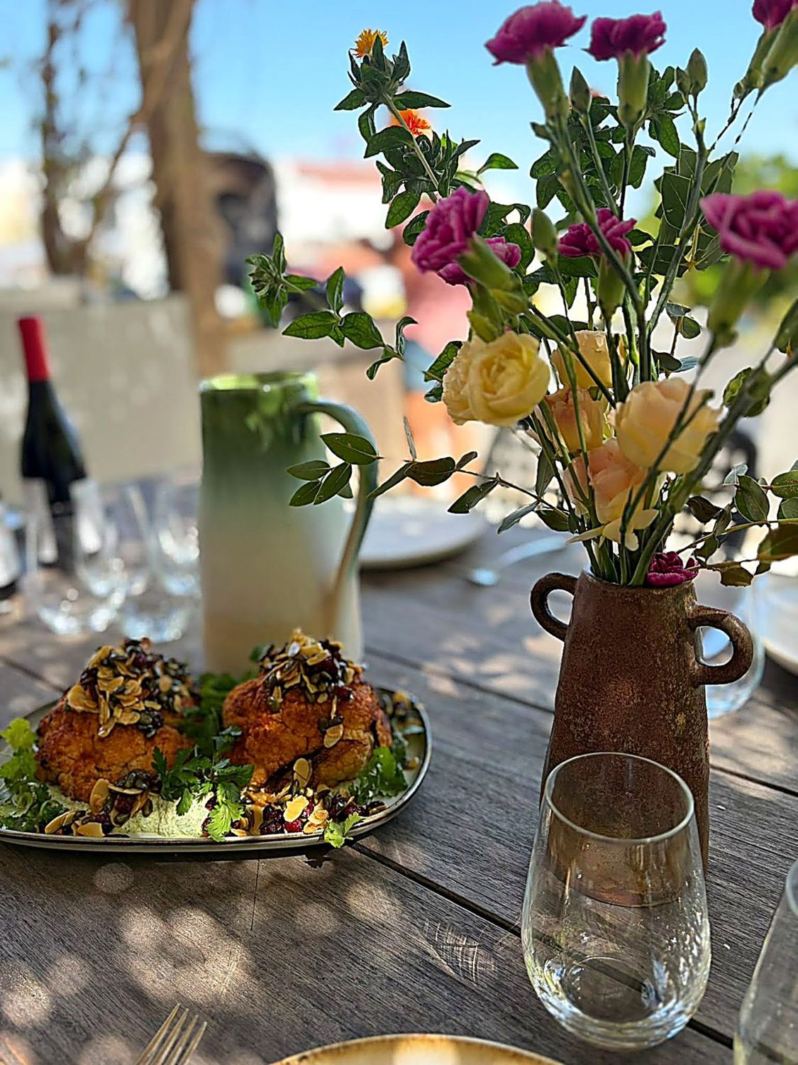 A private table set with food and flowers in the Portuguese sun